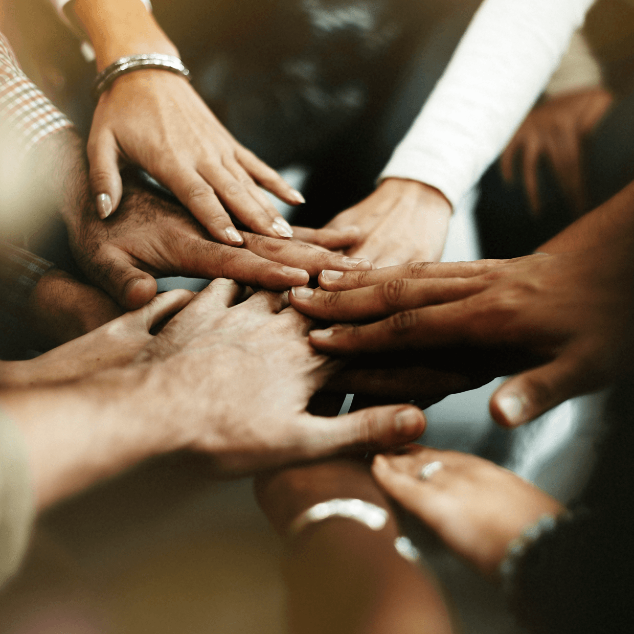 closeup diverse people joining their hands