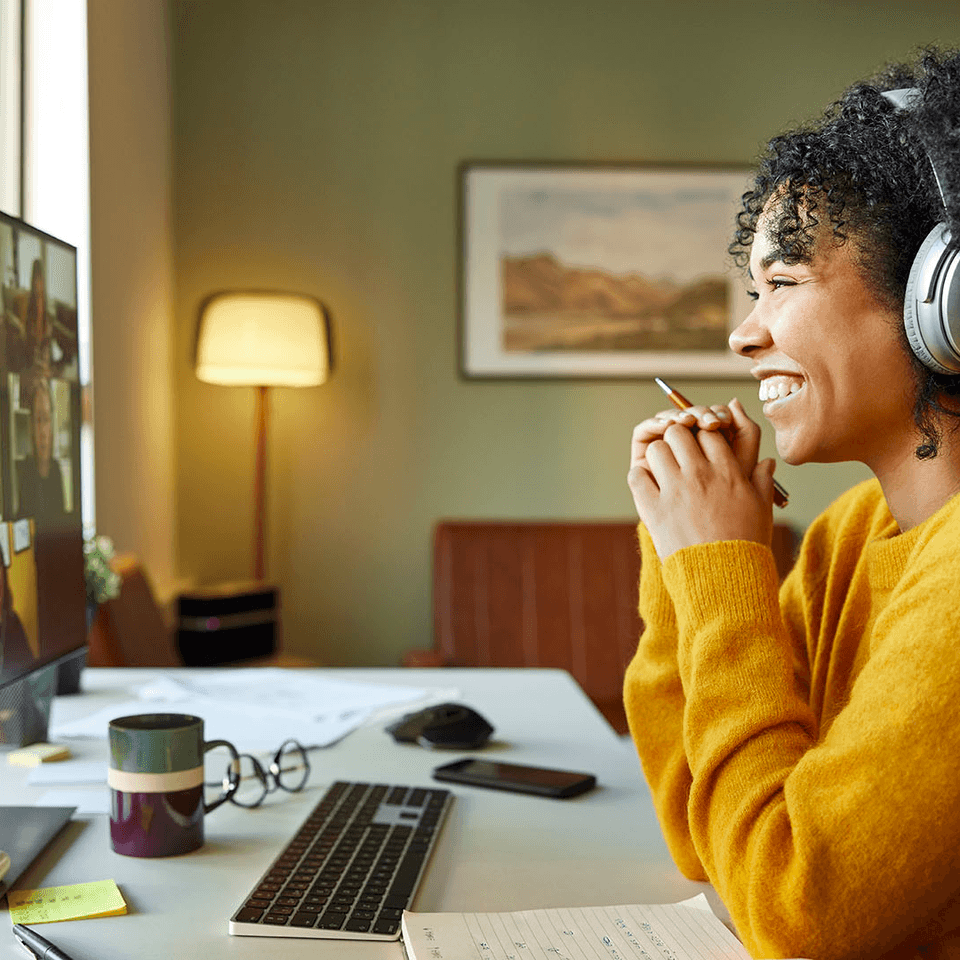A smiling woman looking at her screen