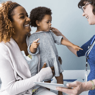 nurse talking to a patient holding a baby