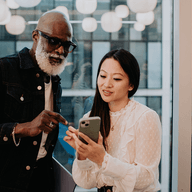 two people together looking at a phone