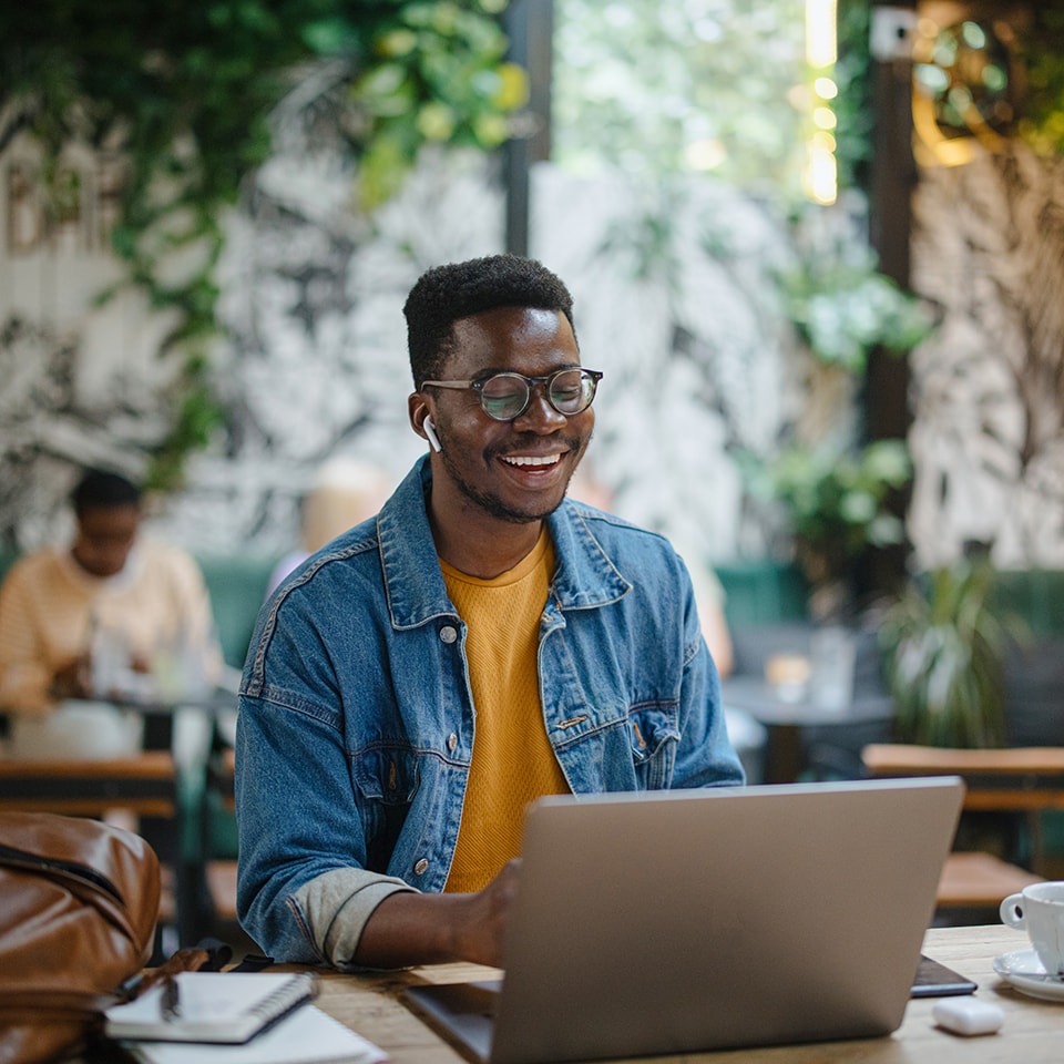 Man working on laptop in cafe