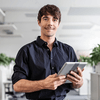 A man smiling and holding a tablet