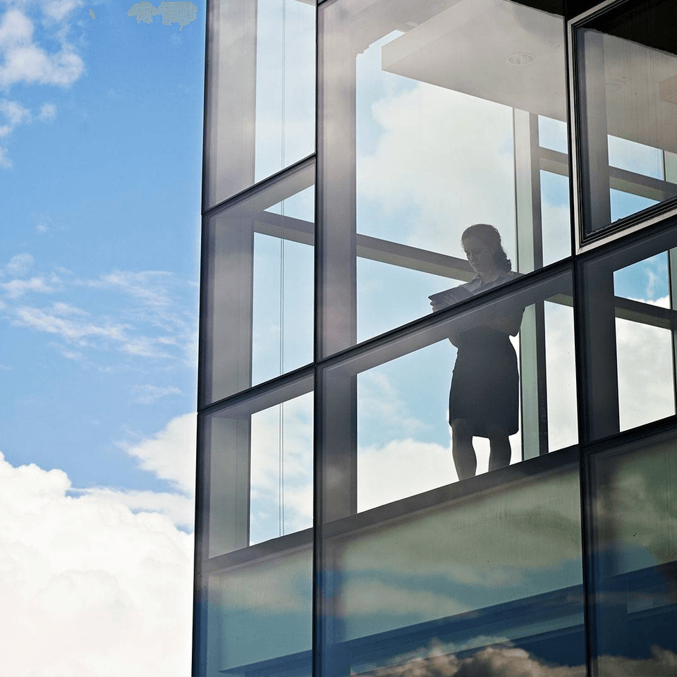 Person standing inside glass building