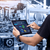 Person using tablet in factory.