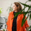 Woman in orange near plants.