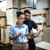Two workers checking inventory tablet.