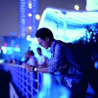 Person standing in cityscape with blue lights