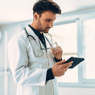 A doctor looking at a tablet