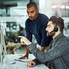 Two men collaborating at computer.