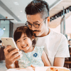 Father and daughter using smartphone.