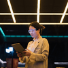 A standing woman working on a tablet