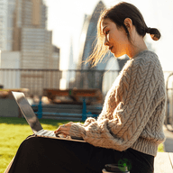 A women on a public park working on her laptop