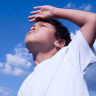 Child shielding eyes under sunlight.