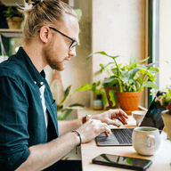 Man working on a computer in a coffee shop