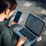 Woman using laptop and phone
