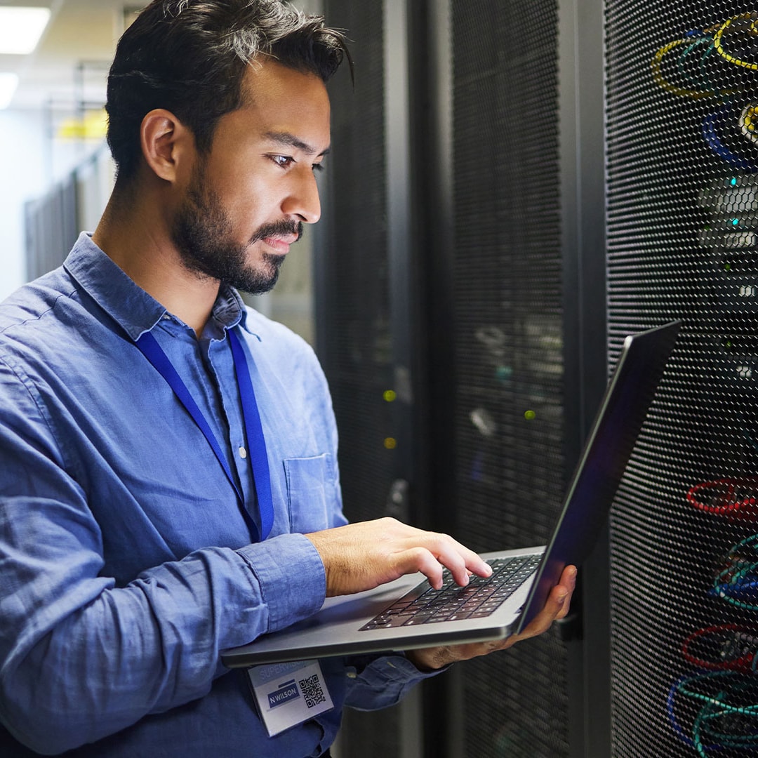 man using a computer in a server room