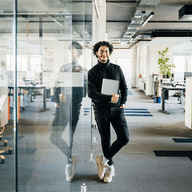person holding a computer in the office smiling
