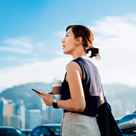 woman walking out of her car holding her phone