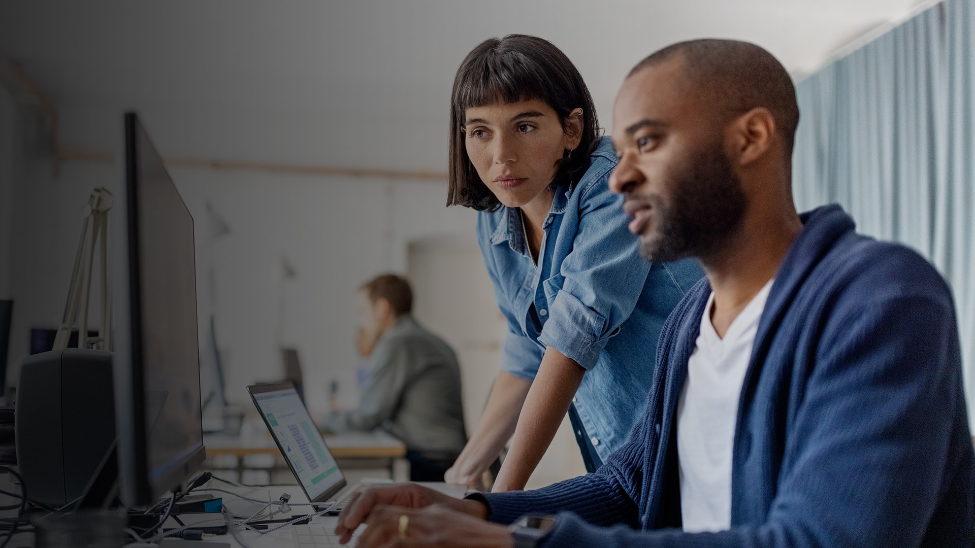 Two businesspeople looking at desktop computer.