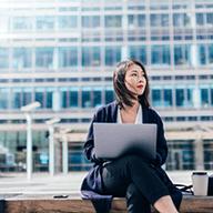 woman sitting outdoors while using her work computer